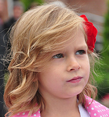 Bambina bionda con fiori nei capelli